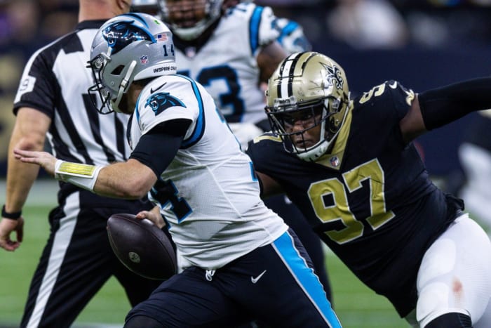 Jan 8, 2023; Carolina Panthers quarterback Sam Darnold (14) scrambles under pressure from New Orleans Saints defensive end Malcolm Roach (97). Mandatory Credit: Stephen Lew-USA TODAY Sports